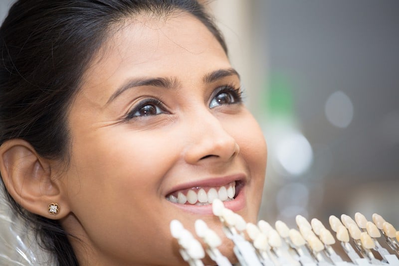 A woman in a dental chair smiling